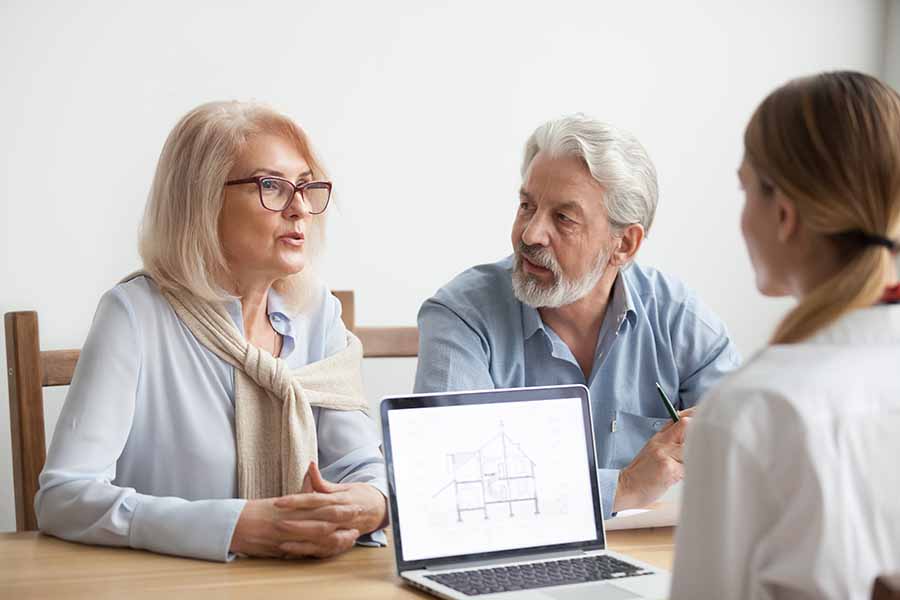 couple looking at home improvement ideas with designer on laptop